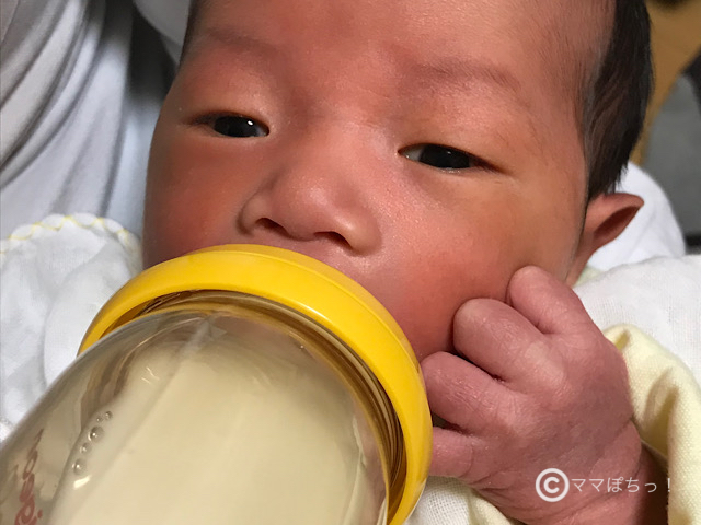 哺乳瓶でミルクを飲む赤ちゃんの写真です。
